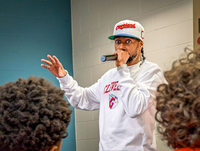 Man wearing Cleveland Sports gear speaking at detention center graduation.